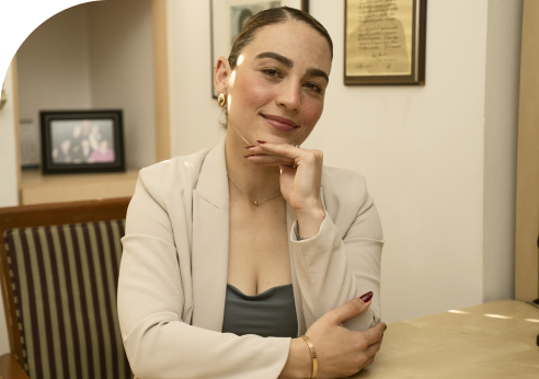 woman smiling and posing for a photograph wearing beige clothes